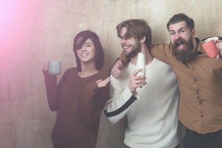 friends have fun and drink yogurt from bottle and cups on beige backgroundの写真素材