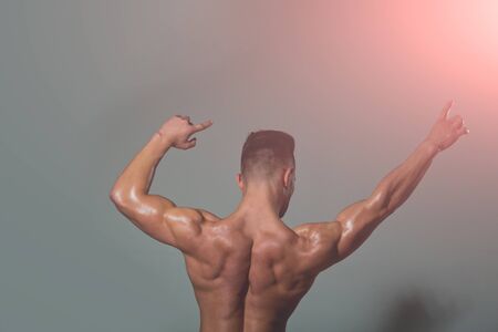 muscular body. sexy man with muscular body and strong back of bodybuilder athlete on grey background, sport and trainingの写真素材