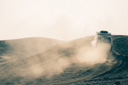 Jeep driving in desert on sandy surface on white sky background. Dune bashing. Safari. Offroad adventure. Travel, travelling. Summer vacationの写真素材