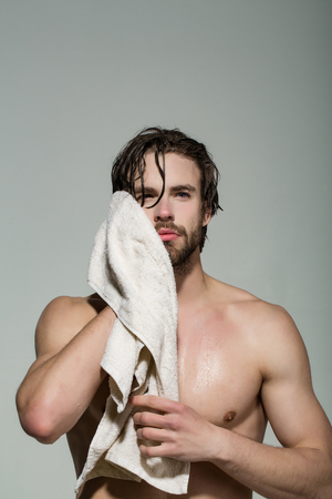 naked man with muscular wet body hold towel in bath or shower after washing in morning on grey backgroundの写真素材
