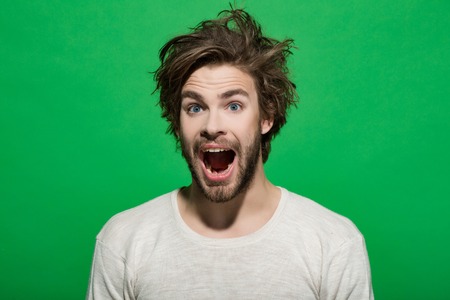 happy man with long stylish uncombed hair and smiling bearded man on green background, morning and barbershop fashionの写真素材