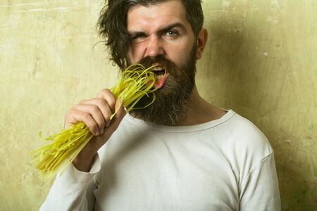 Healthy food and dieting. Hipster eating Italian macaroni. Cook or chef bearded man. Cooking raw spaghetti in restaurant. Man with pasta in hand.の写真素材