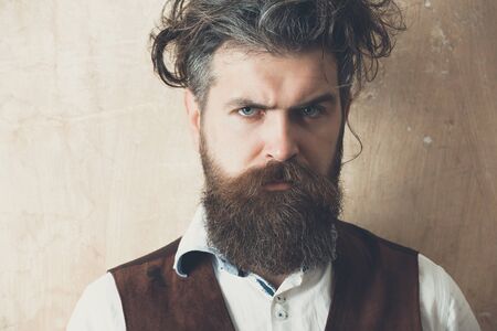 Man with long beard, moustache and messy hair. Bearded hipster with serious face on beige background. Barbershop. Beauty salonの写真素材