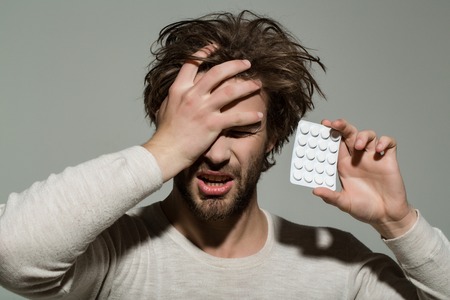 Guy hold dieting pill and vitamin. Health and medicine. Man with pills in blister pack. Treatment...