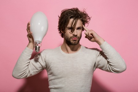 Young guy got an idea. Energy and electricity concept. Man with big lamp. Power and business...