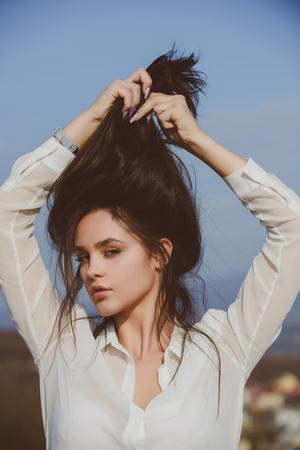 Woman with brunette hair and fresh makeup. Fashion model on blue sky background. Girl with cute face. Sexy woman outdoor. Beauty and fashion.の写真素材