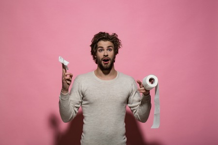 Man with surprised face hold toilet paper. Guy in underwear in morning. Hygiene and sanitary. Sterility and purity. WC and restroom.の写真素材