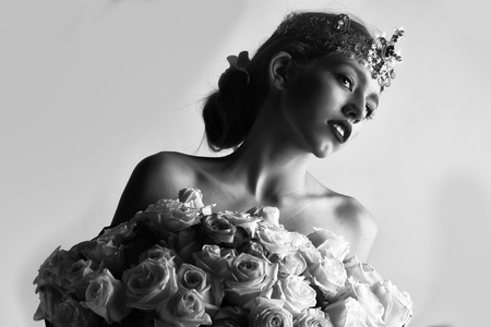 beauty with luxury crown with diamond and gem has bare shoulders hold rose bouquet, black and whiteの写真素材