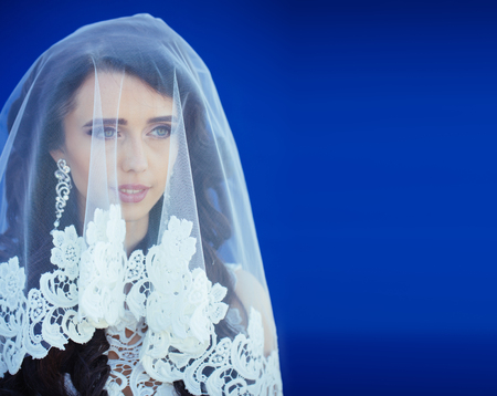 Woman has stylish long hair. Girl with fashionable makeup. Beauty salon and fashion. Cosmetics and skincare. Wedding veil on bride.の写真素材