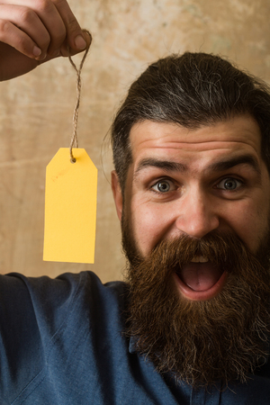 Guy hold shopping tag. Sale and shopping. Businessman take paper. Black Friday in shop. Man with beard on happy face.の写真素材