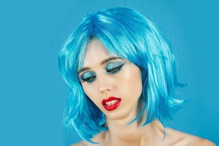 Woman in blue wig with fashionable makeup. Girl with bright artificial hair. Hairdresser salon and barbershop. Beauty and fashion. Fashion model with naked body and red lips.の写真素材