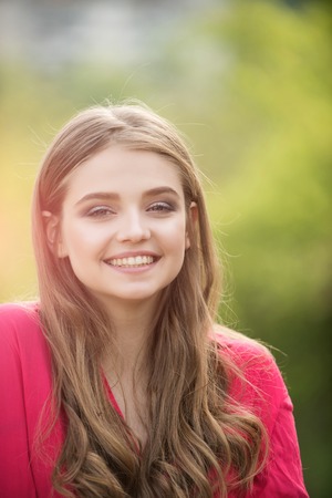 happy girl with long hair on blurred green backgroundの写真素材