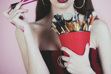 Girl with fashionable makeup. Woman has stylish long hair with brush. Beauty salon and fashion. Cosmetics and skincare.の写真素材