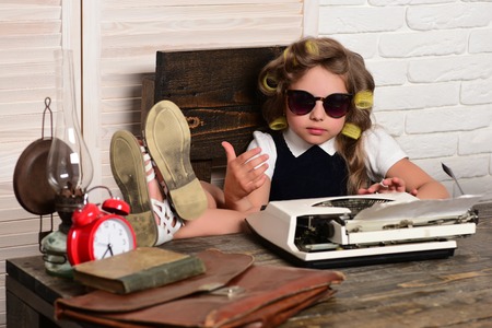 Child with briefcase and alarm clock. Kid choose career in glasses. Small girl with curler in hair. Education and childhood. Little baby secretary.の写真素材