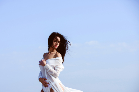 Woman with brunette hair and fresh makeup. Girl with cute face. Beauty and fashion. Sexy woman outdoor. Fashion model on blue sky background.の写真素材