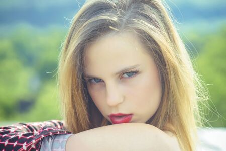 Fashionable model on natural background. Beauty and fashion. Skin and hair care. Girl posing with long blond hair. Woman with red lips makeup.の写真素材