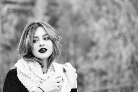 woman with lipstick on lips in dress and scarf outdoor, copy space, black and whiteの写真素材