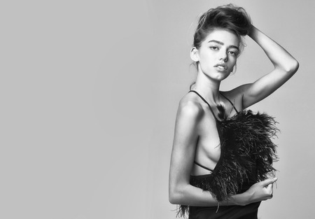 woman or cute sexy girl with long hair in fashionable dress with feather, black and white, copy spaceの写真素材