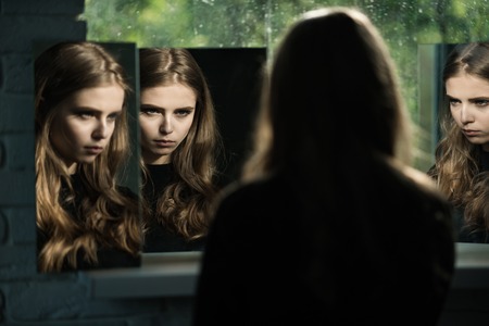Woman with long hair and pretty face. Skincare and salon. Girl look at mirror. Beauty and fashion. Hairdresser and barber.の写真素材