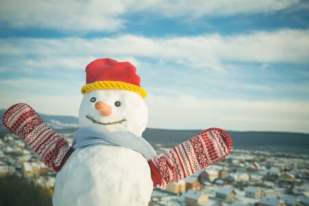 Snowman with in hat and mittens. New year snowman from white snow outdoor. Winter activity and party. Happy holiday and celebration. Christmas or xmas decoration.の写真素材