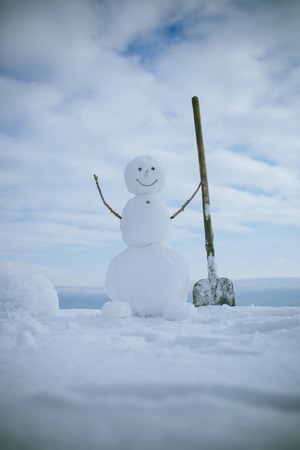 New year snowman from white snow outdoor. Christmas or xmas decoration. Winter activity and party. Happy holiday and celebration. Snowman with shovel.の写真素材