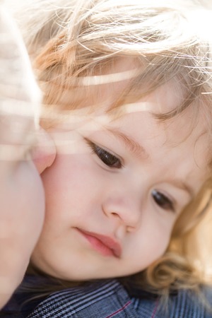 Mother kissing child on sunny day outdoors. Mothers day and happy childhood. Family love concept.の写真素材