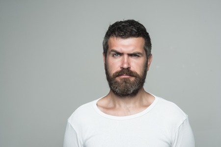 Hipster with serious face. Feeling and emotions. Guy or bearded man on grey background. Barber...