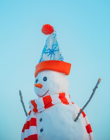 christmas or new year snowman from snow in winter hat and scarf outdoorの写真素材