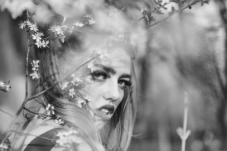 Beautiful sensual young woman enjoying beauty in a flowering spring gardenの写真素材