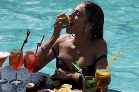 Summer vacation and party. Swimming and relax in water pool. Woman with alcoholic beverage and...