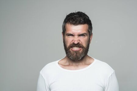 Man with long beard and mustache. Hipster with angry face. Guy or bearded man on grey background. Feeling and emotions. Barber fashion and beauty, copy spaceの写真素材