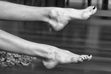 Two straight beautiful female legs bare foot with red nail polish, glamour fashion concept, health care, horizontal pictureの写真素材