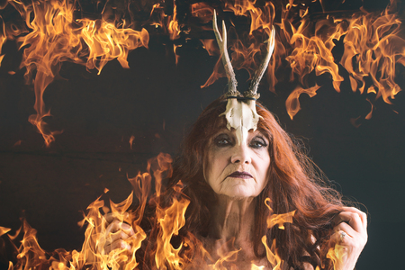 Halloween traditional party. Halloween holiday celebration. woman with long red hair in fire. old...