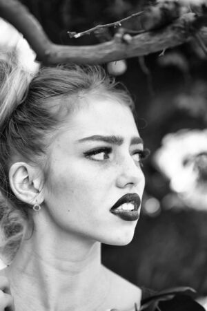 Sensual girl with fresh beautiful red poppy seed flower outdoor in springの写真素材