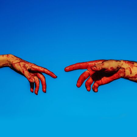 zombie hands male and female of man war soldier and girl or woman with bloody wounds and red blood on skin on blue sky backgroundの写真素材