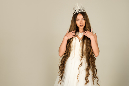 woman with long healthy hair in wedding dress on grey background, hairdresser and beauty salon, copy spaceの写真素材