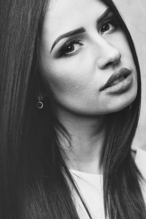 Pretty woman face or cute girl portrait with long brunette hair has sexy lips and fashionable makeup on beautiful eyesの写真素材