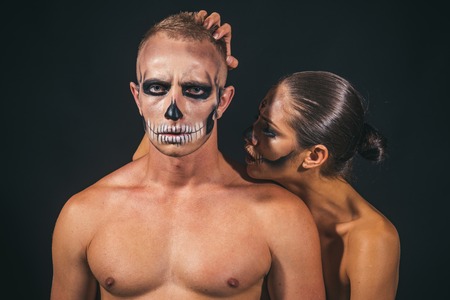 Halloween couple with makeup on face on black background. Couple in love with naked body. woman and man has scary face embrace. Halloween Holiday and celebration. Zombie party and horror.の写真素材