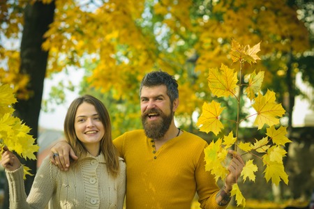 Autumn happy couple of girl and man outdoor. Nature season and fall holiday. Love relationship and romance. Couple in love in autumn park. Man and woman at yellow tree leaves.の写真素材
