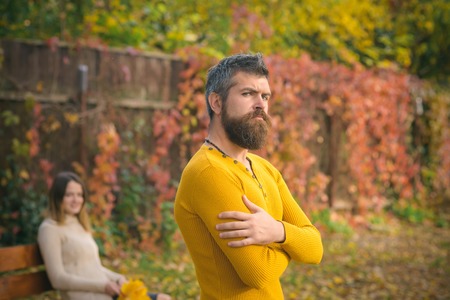 Love relationship and romance. Man and woman with yellow tree leaves. Couple in love in autumn park at bench. Autumn happy couple of girl and man outdoor. Nature season and fall holiday.の写真素材