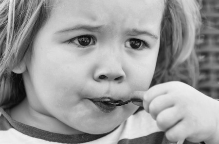 Cute baby boy, small, little, blond child eating tasty ice cream