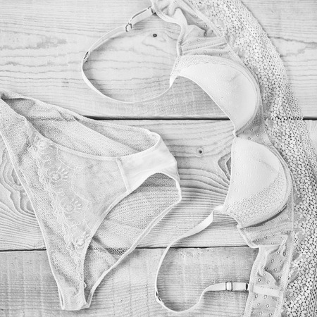 female erotic fashionable lace bra and panties or lingerie beige pink or peach color on wood or wooden backgroundの写真素材