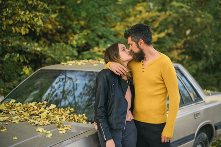 travelling and fall holiday. Love relationship and romance. Man and woman at car. Couple in love in autumn park. Autumn happy couple of girl and man outdoor.の写真素材