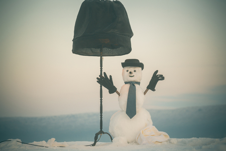 New year snowman spy agent with lamp. Xmas or christmas party. Snowman gentleman in winter black hat, scarf and gloves. Happy holiday celebration. Christmas and winter fashion.の写真素材