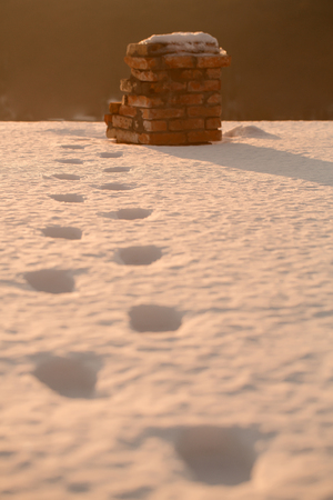 foot trace of santa claus on snow lead to brick chimney, midnight, christmas and new year, winter...