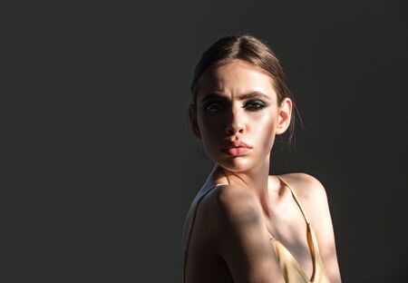 Girl or woman with smokey eyes makeup face pose on grey background. Beauty, youth, skin care, health concept, copy spaceの写真素材