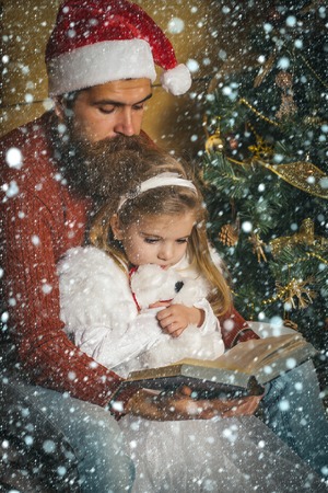 new year christmas snow concept Santa claus kid and bearded man at Christmas tree. Xmas party celebration, fathers day. Winter holiday and vacation. New year small girl and man, fairytale. Christmasの写真素材