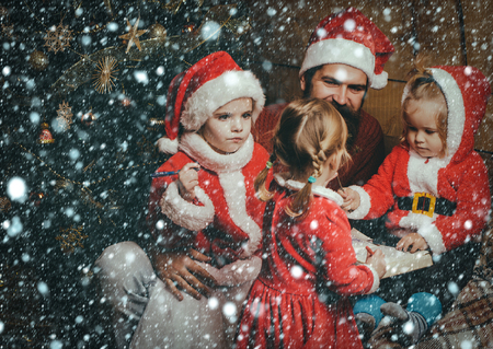 christmas new year snow concept Christmas happy children and father read book. Santa claus kid and bearded man at Christmas tree. Xmas celebration, fathers day. Winter holiday and vacation. New yearの写真素材