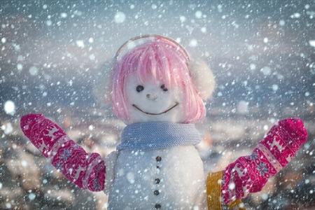 christmas new year snow concept Snowman girl in winter pink wig hair with bag. Xmas or christmas party. New year snowman with shopping bag. Happy holiday celebration. Christmas and winter fashion.の写真素材