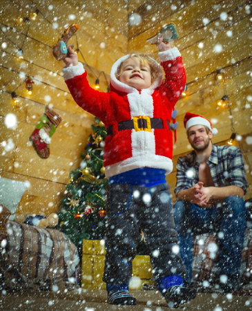 christmas new year snow conceptChristmas happy child and father with gift on wooden background.の写真素材